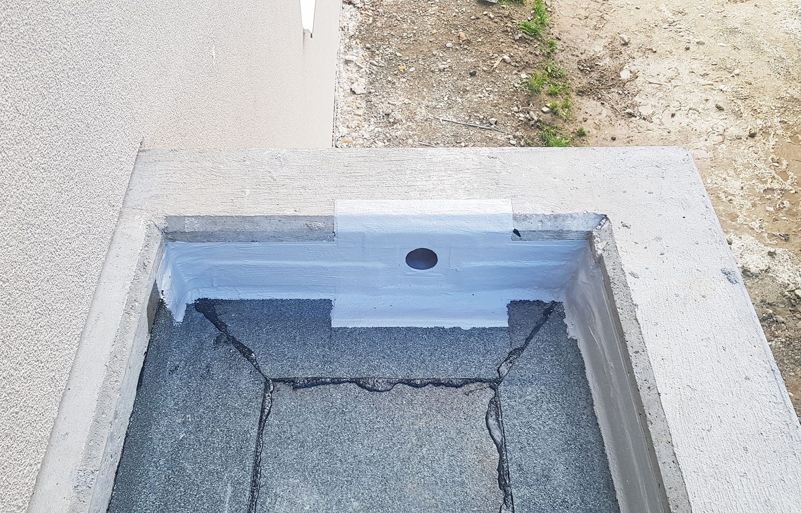 Dachablauf in einem Betonrand mit abgedichtetem Anschluss
