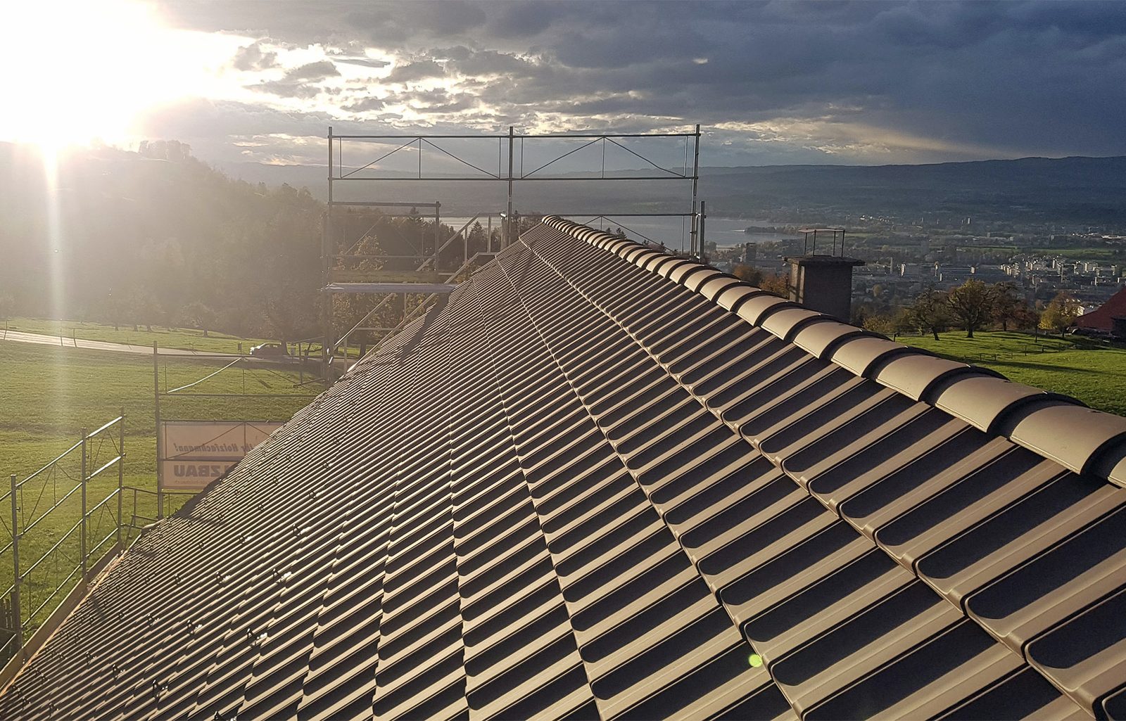 Ziegeldach mit First im Gegenlicht und Blick auf den Zürichsee