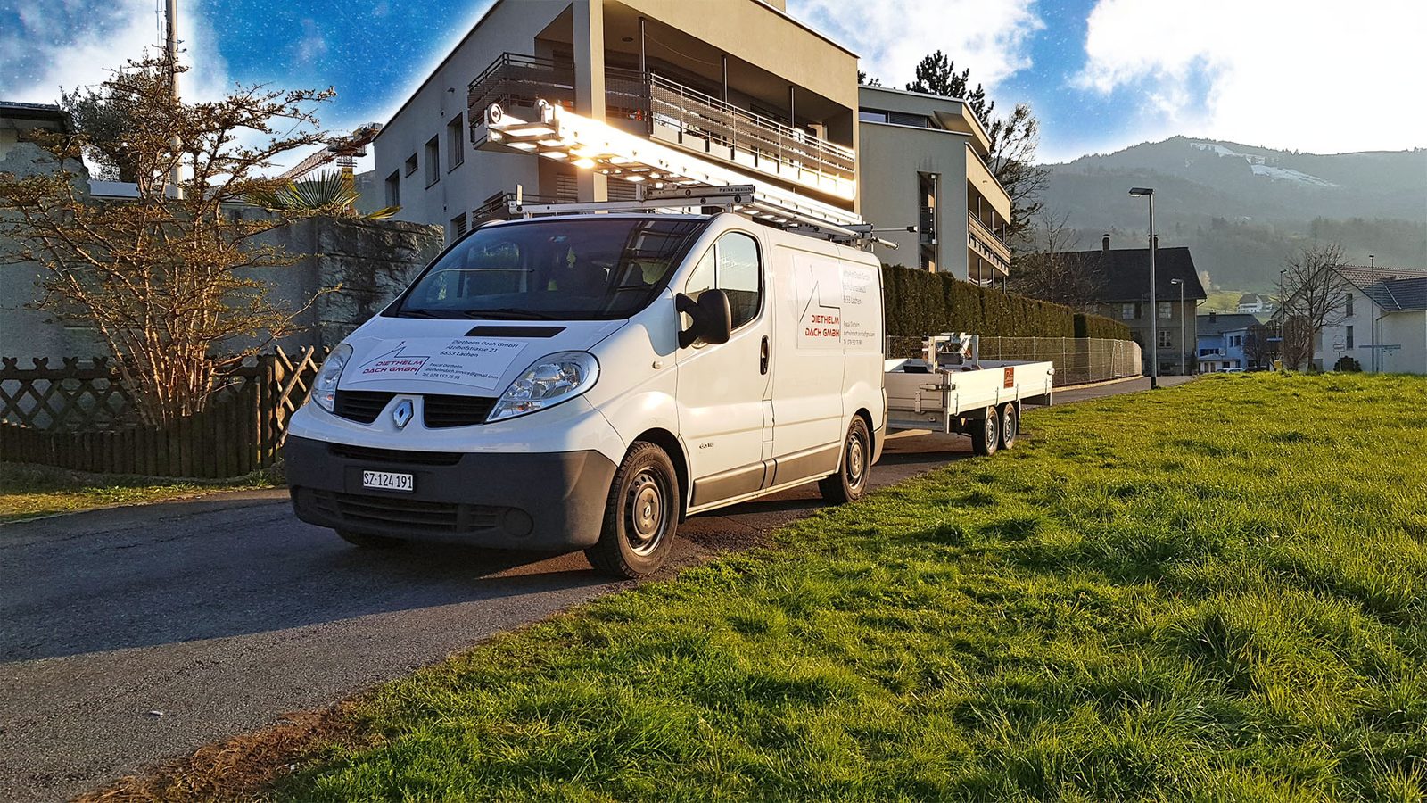 Weisser Transporter der Diethelm Dach GmbH mit Anhänger vor einem Wohnhaus